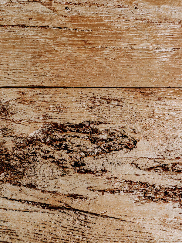 Nahaufnahme von strukturierten Holzbrettern mit natürlichen Ästen, Maserungen und einem verwitterten, rustikalen Aussehen.